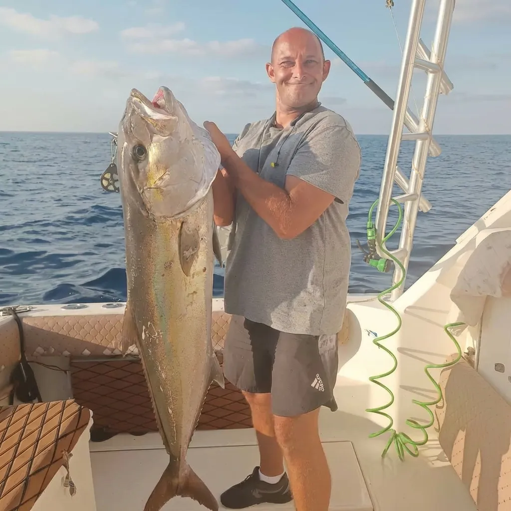 גבר מחזיק דג גדול שנתפס במהלך שייט דייג בחיפה