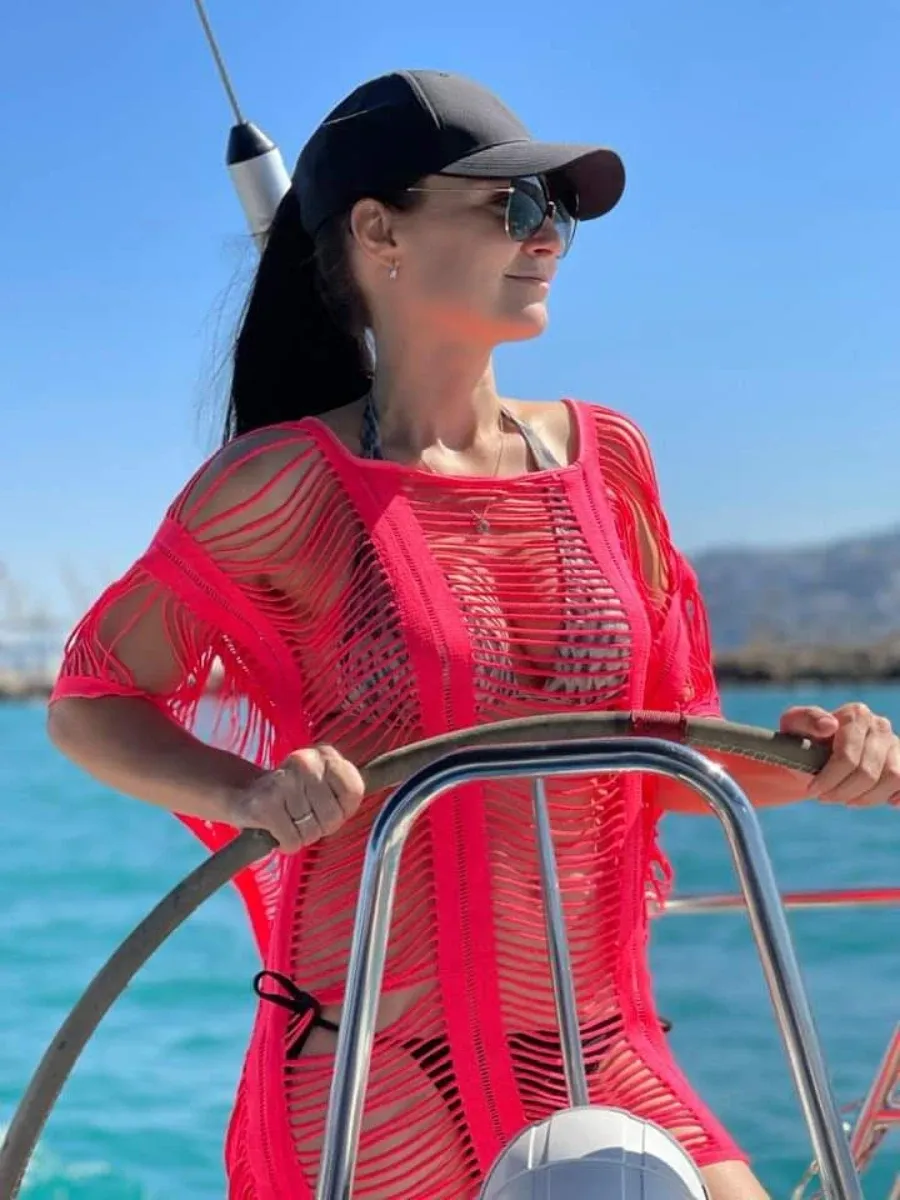 סקיפרית בחולצה אדומה משיטה יאכטה בים